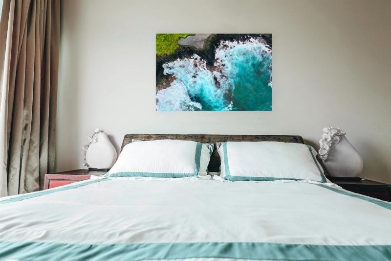 Print hanging on wall with bed