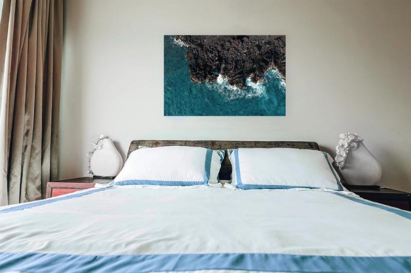 Print hanging on wall with bed