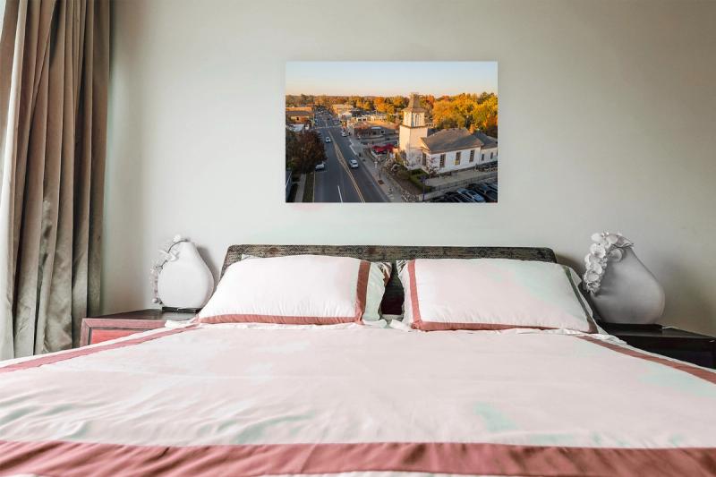 Print hanging on wall with bed