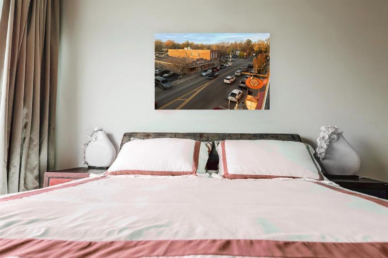 Print hanging on wall with bed