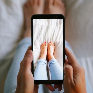 A woman user her phone to take a picture of her feet