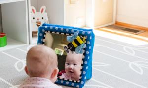Spiegelspiel – Baby sieht einen Freund im Spiegelbild