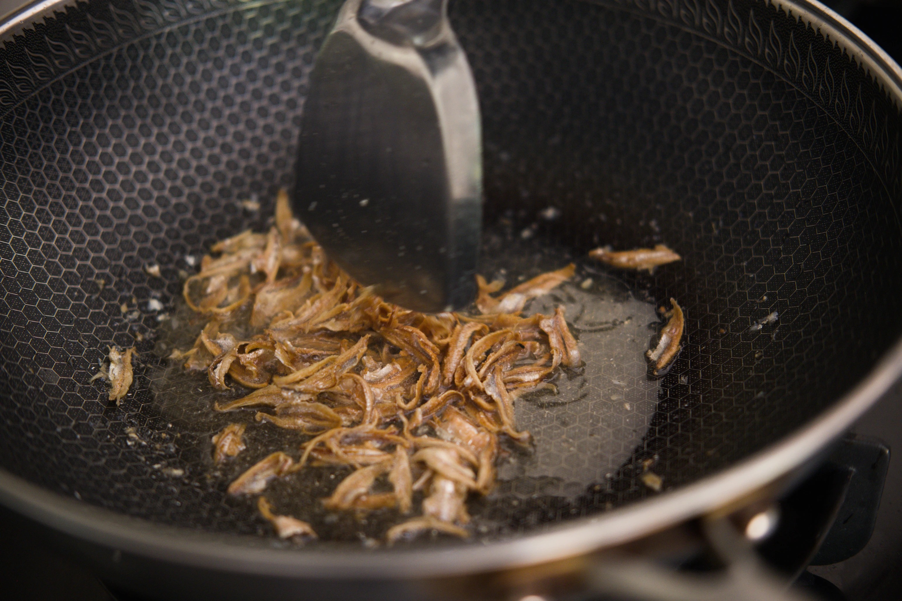 Frying ikan bilis in the wok