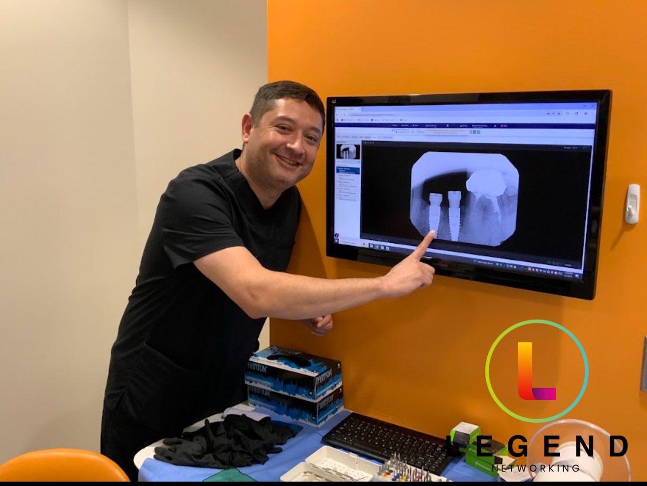 Dentist pointing at dental X-ray images on a large monitor at TriPoint Dental, Durham, NC