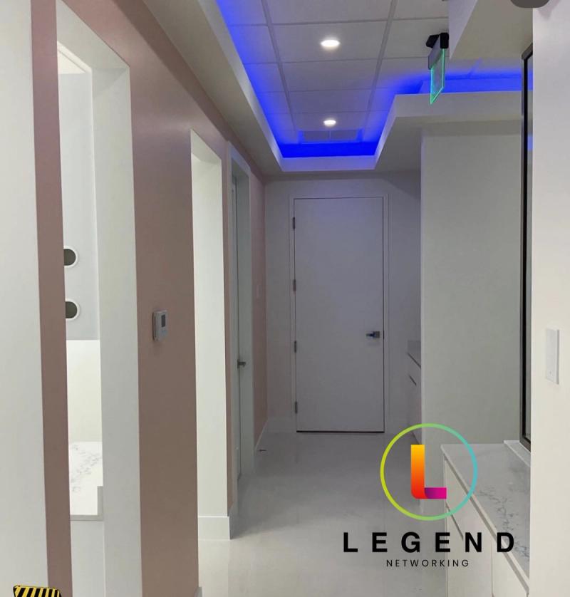 Corridor with blue ceiling lighting and treatment rooms at Ocean Vibe Dental in Fort Myers