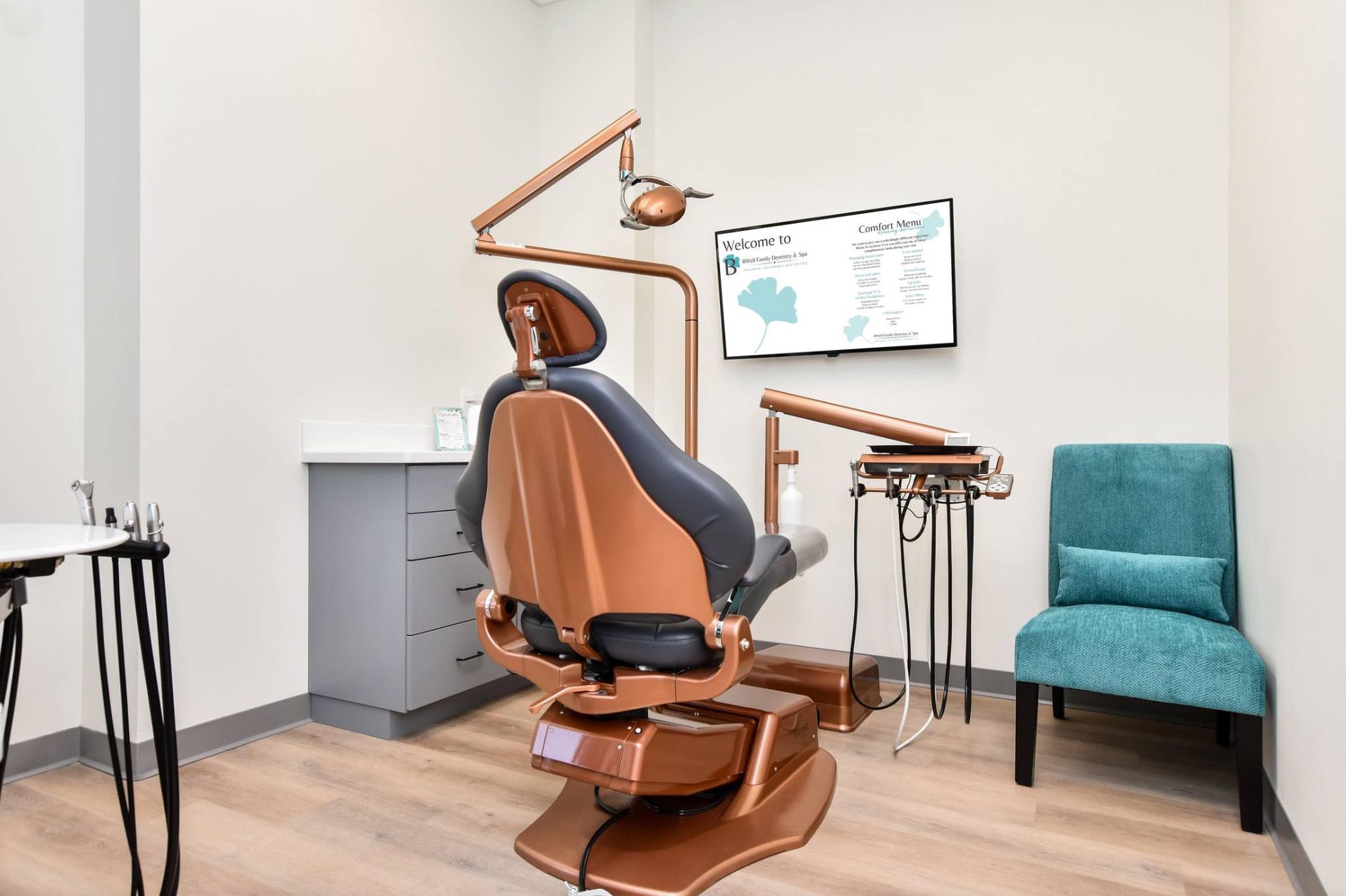 Operatory with copper dental chair and wall monitor at BWell Family Dentistry & Spa, Simpsonville, SC