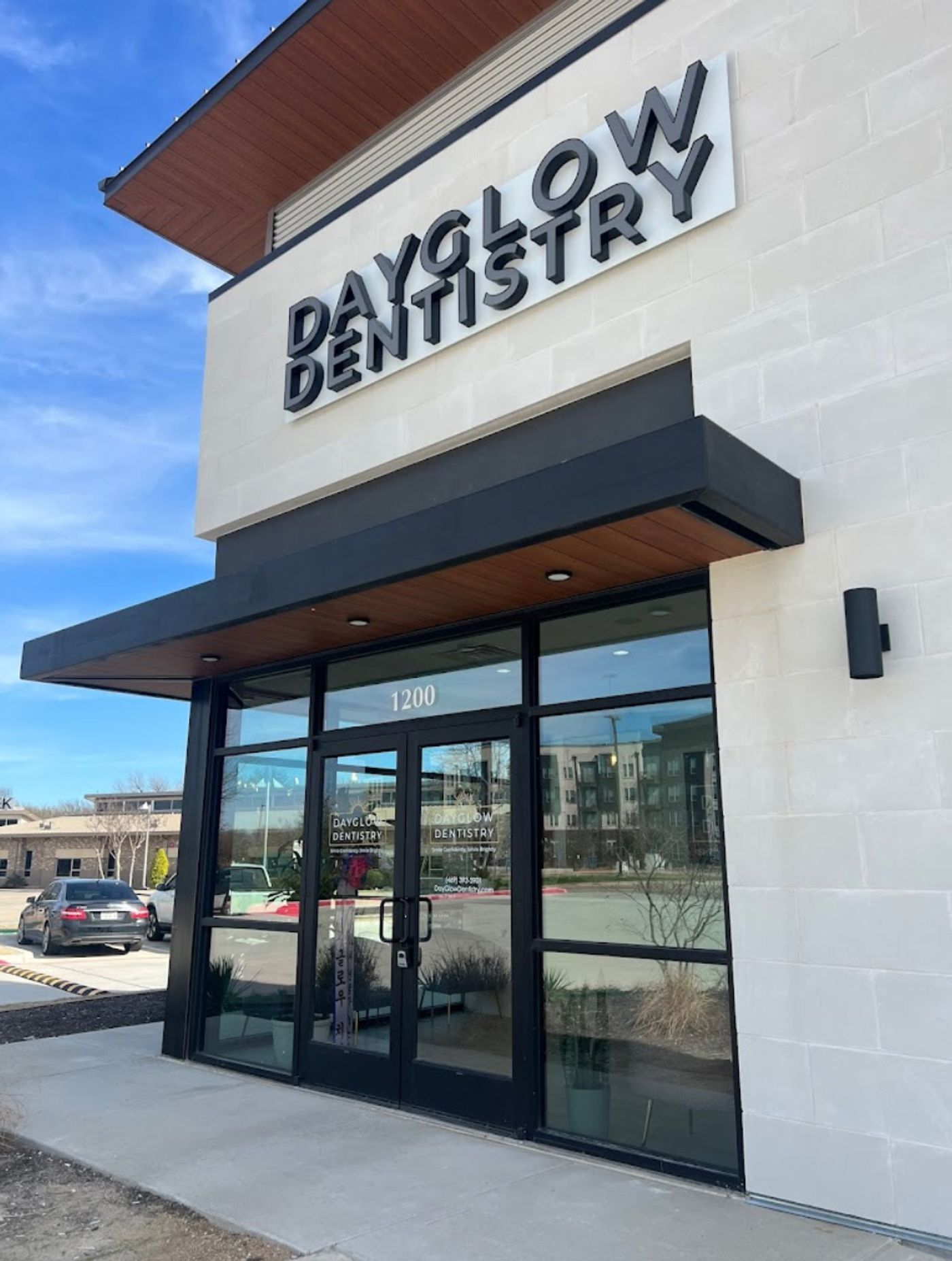 Dayglow Dentistry sign above the glass entrance of the new office in Allen, TX