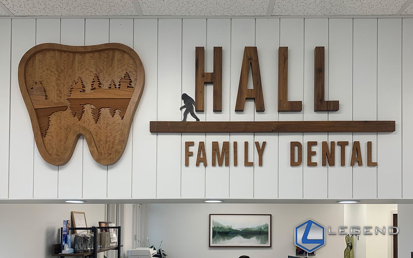 Wooden tooth emblem and Hall Family Dental sign above the reception area in Benton, KY