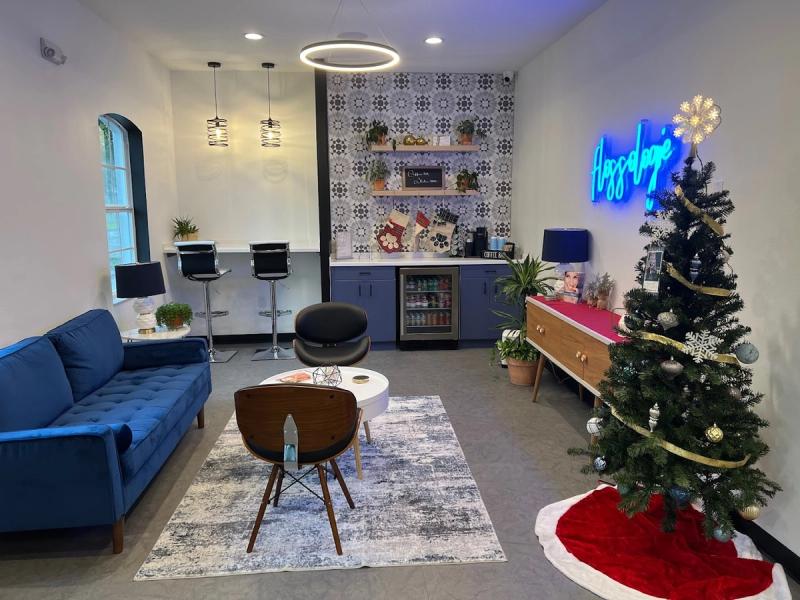 Waiting area with sofa, coffee bar and neon sign at Flossologie Dental Studio in Tampa