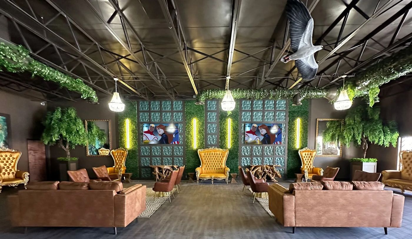 Jungle-themed waiting area with gold chairs, sofas and green walls at Smile Kingdom in El Paso, TX