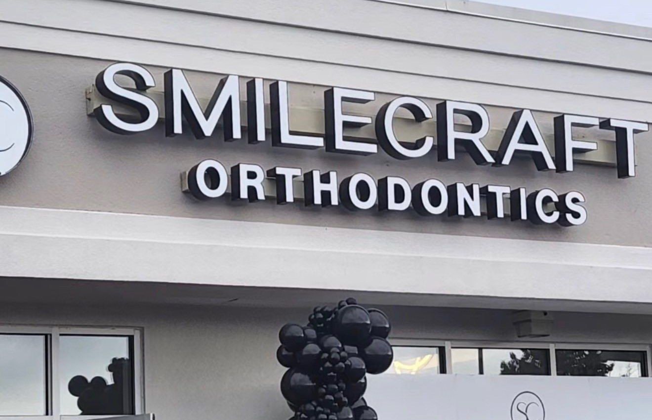 Smile Craft Orthodontics storefront sign in Jessup, Maryland, with opening-day balloons.