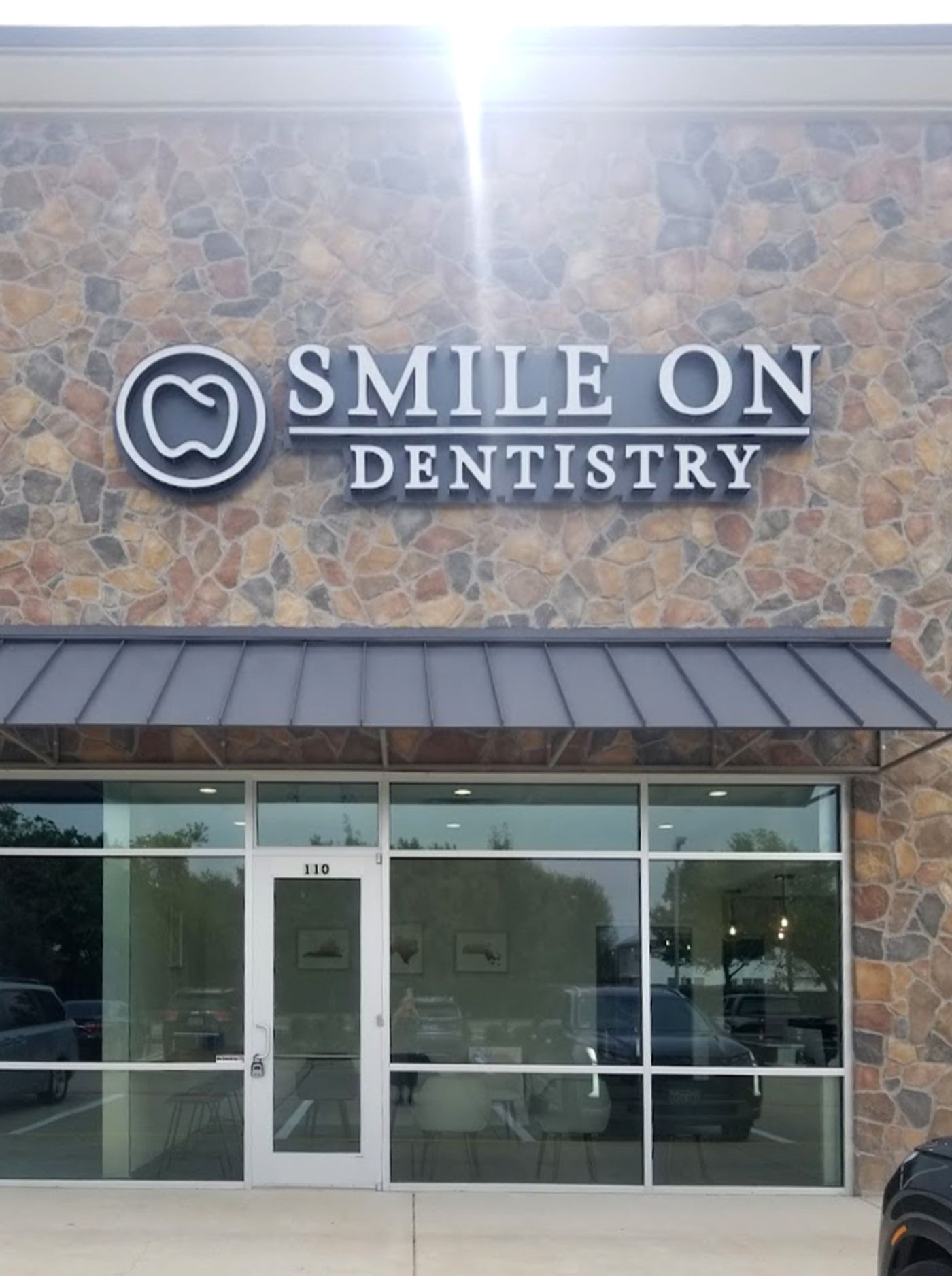 Smile On Dentistry sign above the glass storefront entrance in McKinney, TX