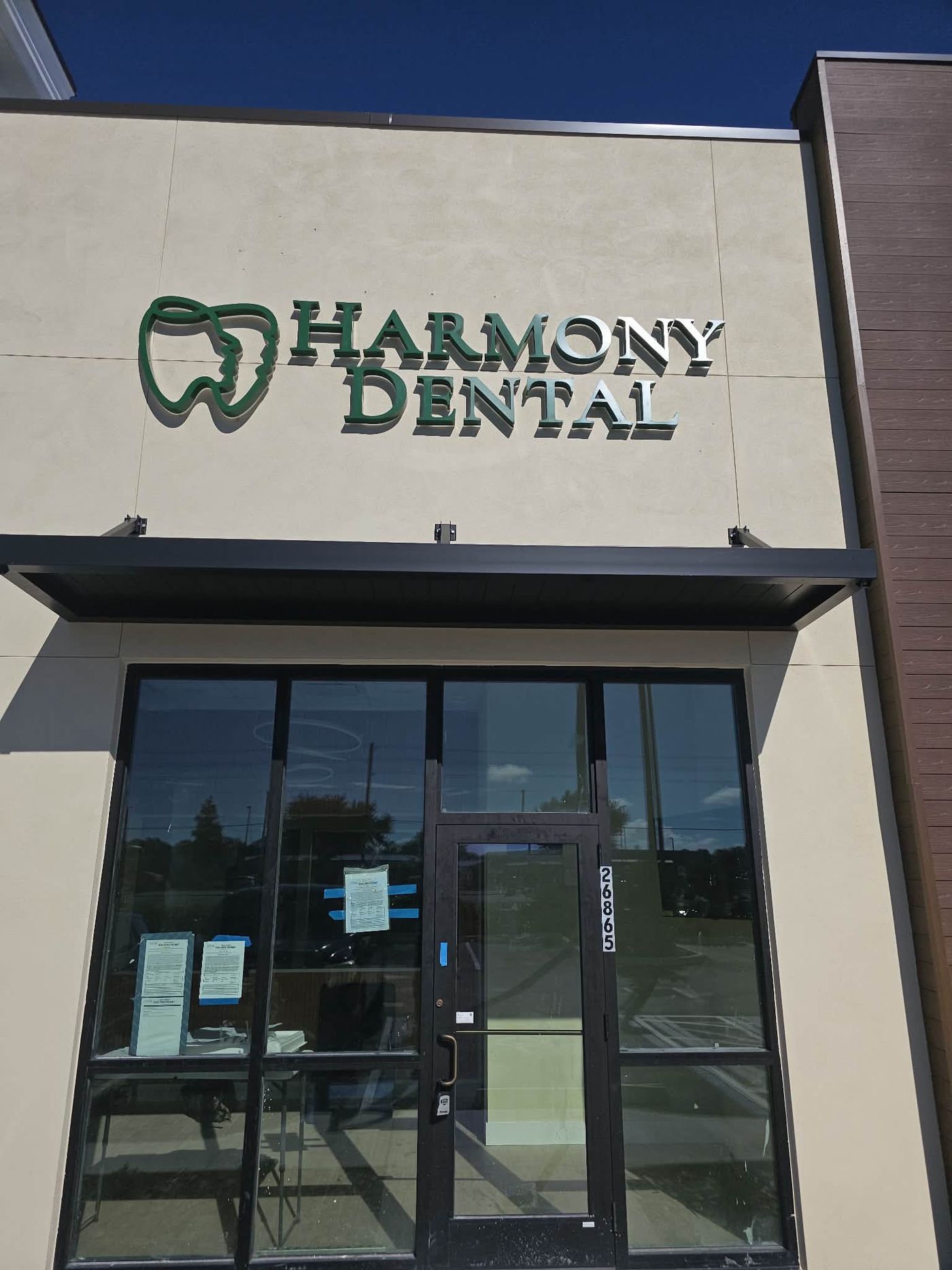 Harmony Dental sign above the glass entrance of the second location of Harmony Dental and Facial Aesthetics, Wesley Chapel, FL