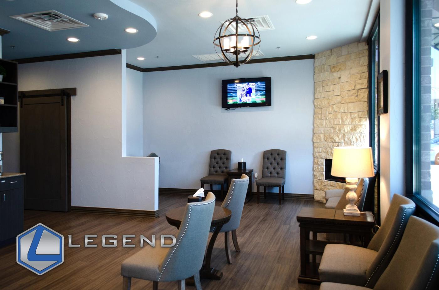 Waiting area with a wall-mounted TV and stone fireplace at 380 Family Dentistry in Prosper, TX