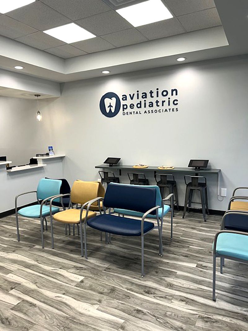 Waiting room with colorful chairs below the Aviation Pediatric Dental Associates wall sign, Memphis, TN