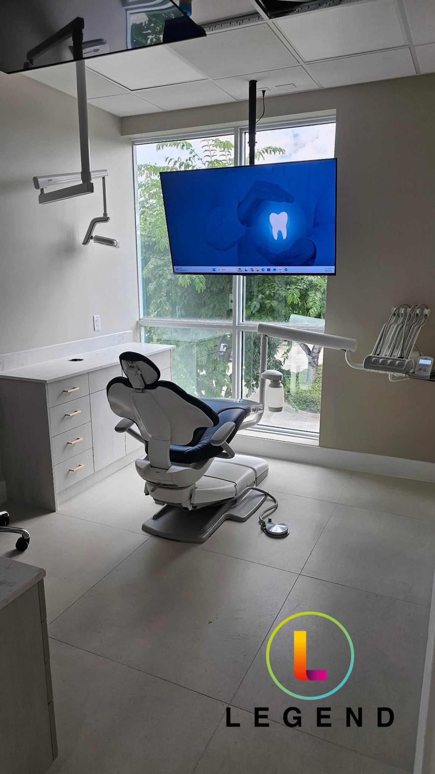 Operatory with dental chair and wall-mounted monitor at Good Hands Dental in Miramar, FL