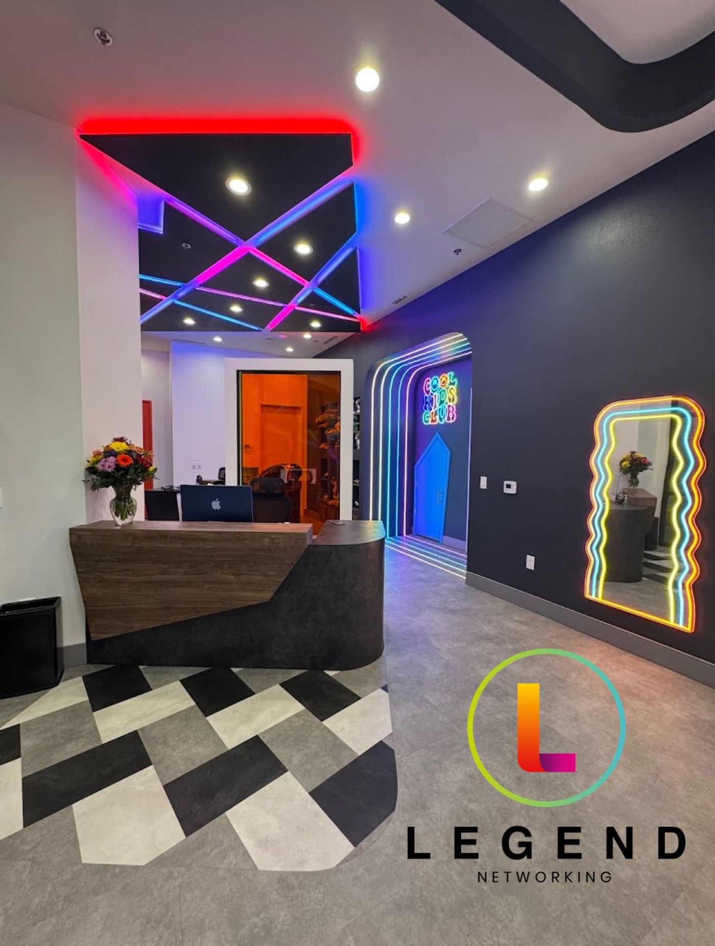 Reception area with front desk computer and neon-lit walls at So Hi Kids and Teens Dentistry, Las Vegas, NV