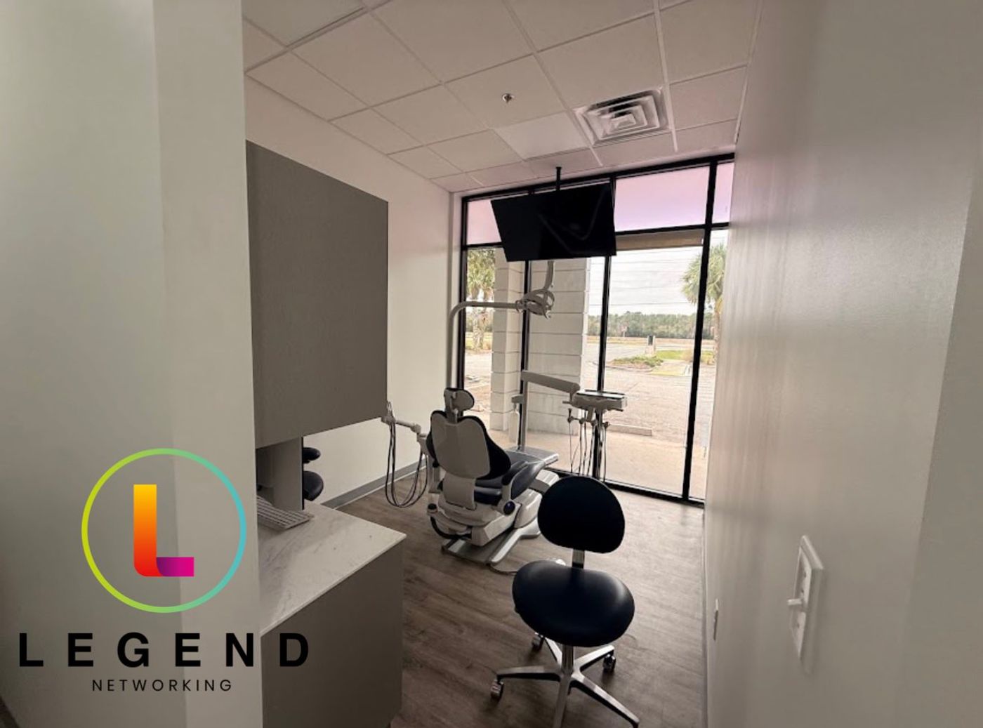 Treatment room with dental chair, stool and wall-mounted TV at Borges Brothers Dental in St. Augustine, FL