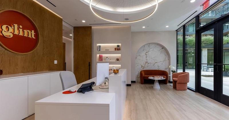 Reception desk, glint logo wall and waiting area at Glint Dental in Austin