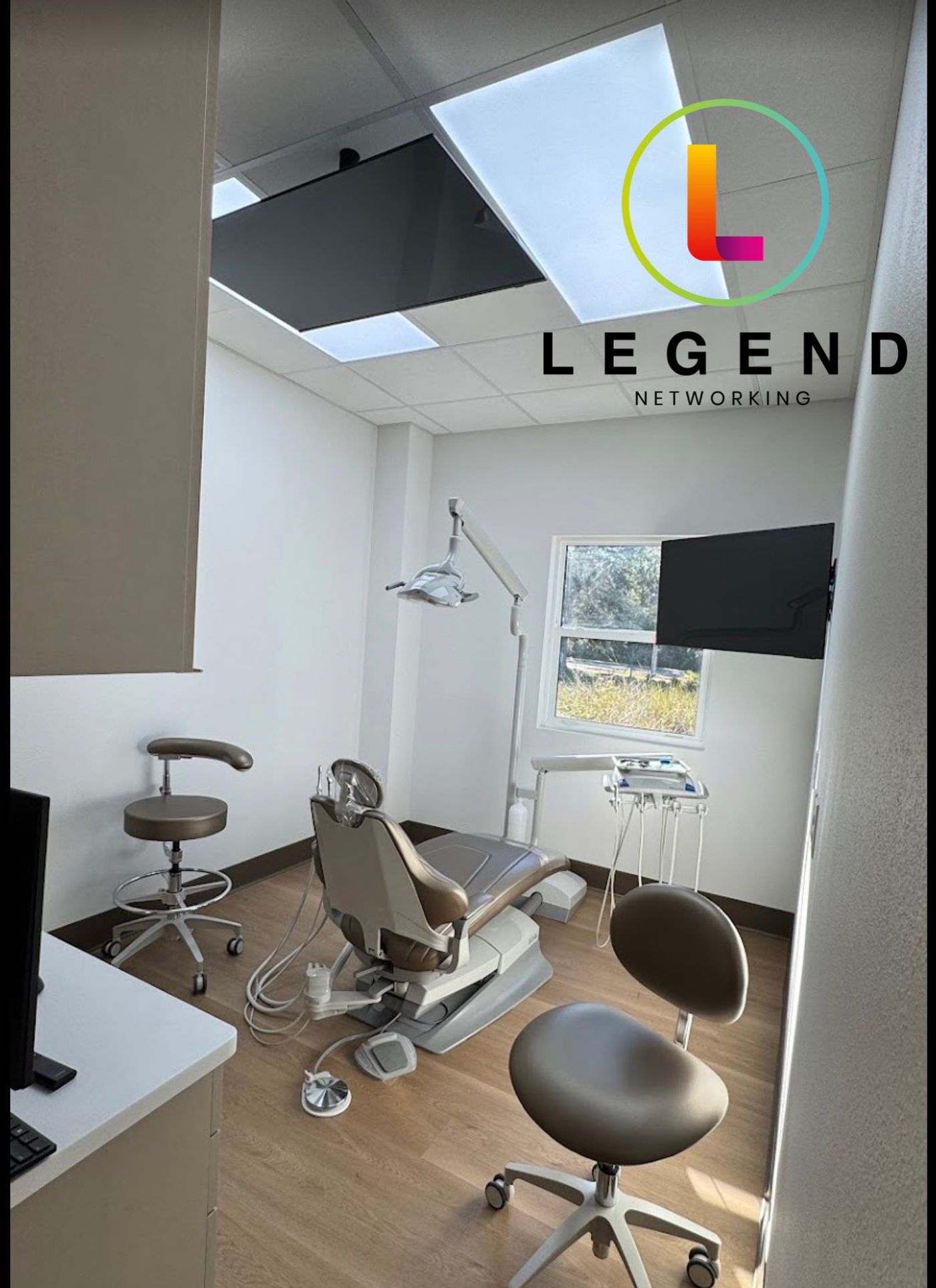 Operatory with dental chair, overhead light and wall-mounted screen at Smile Co. Tampa Palms in Tampa, FL