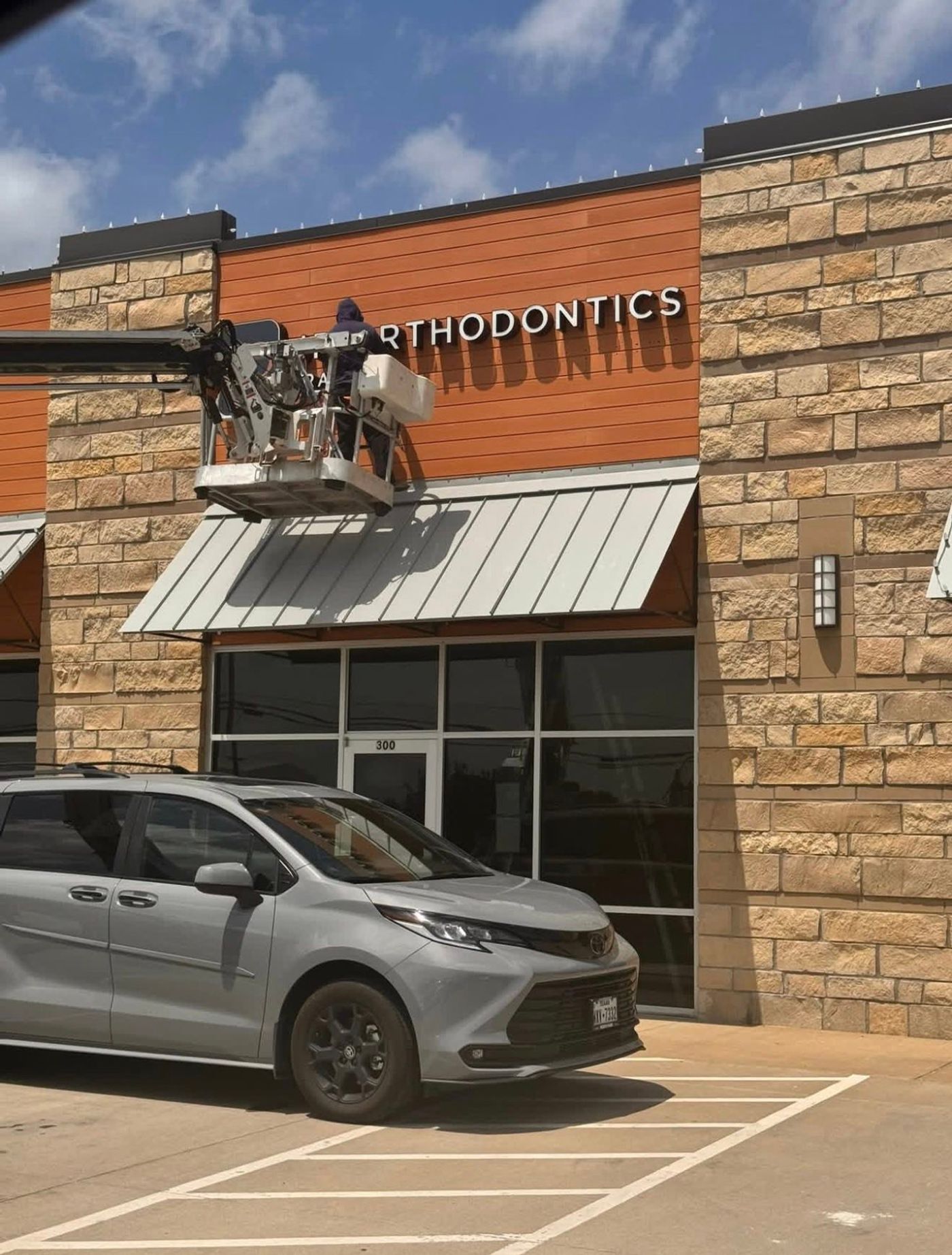 Storefront of JP Orthodontics during exterior signage installation in Gunter, TX