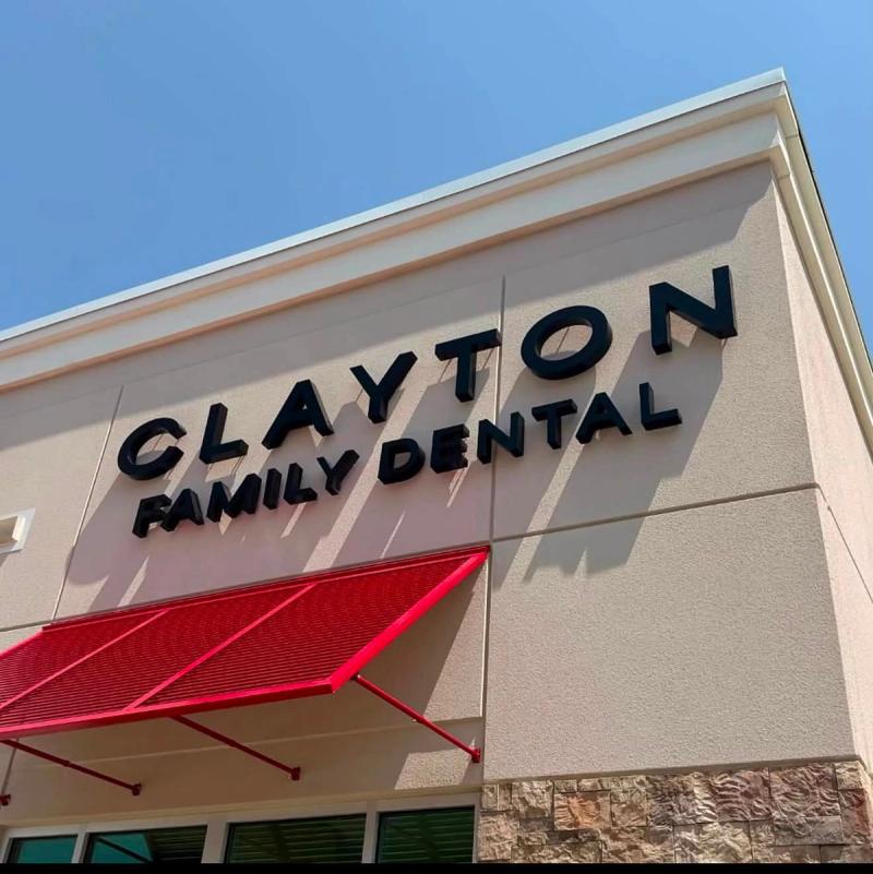 Exterior signage and red awning on the building of Clayton Family Dental in Clayton