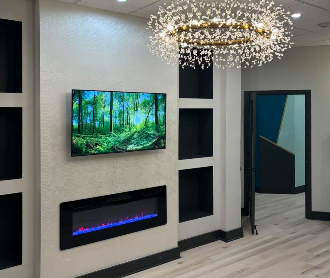 Interior wall with a mounted TV and electric fireplace at Calm Family Dental in Middletown