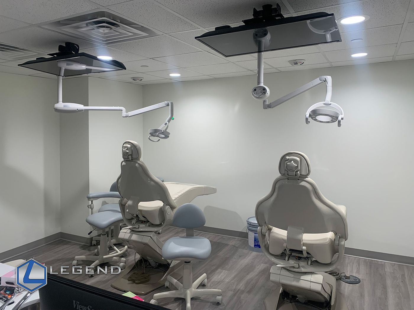 Two treatment chairs with ceiling-mounted monitors and lights at Beyond Pediatric Dentistry in Dallas, TX