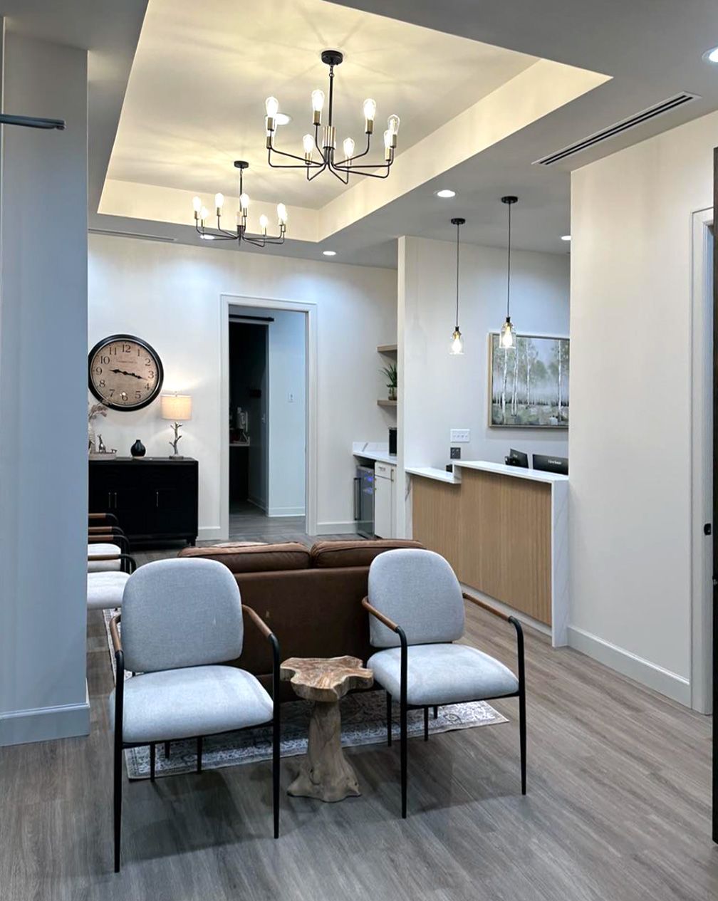 Waiting area with chairs, chandeliers and reception counter at Timberwood Dental in San Antonio