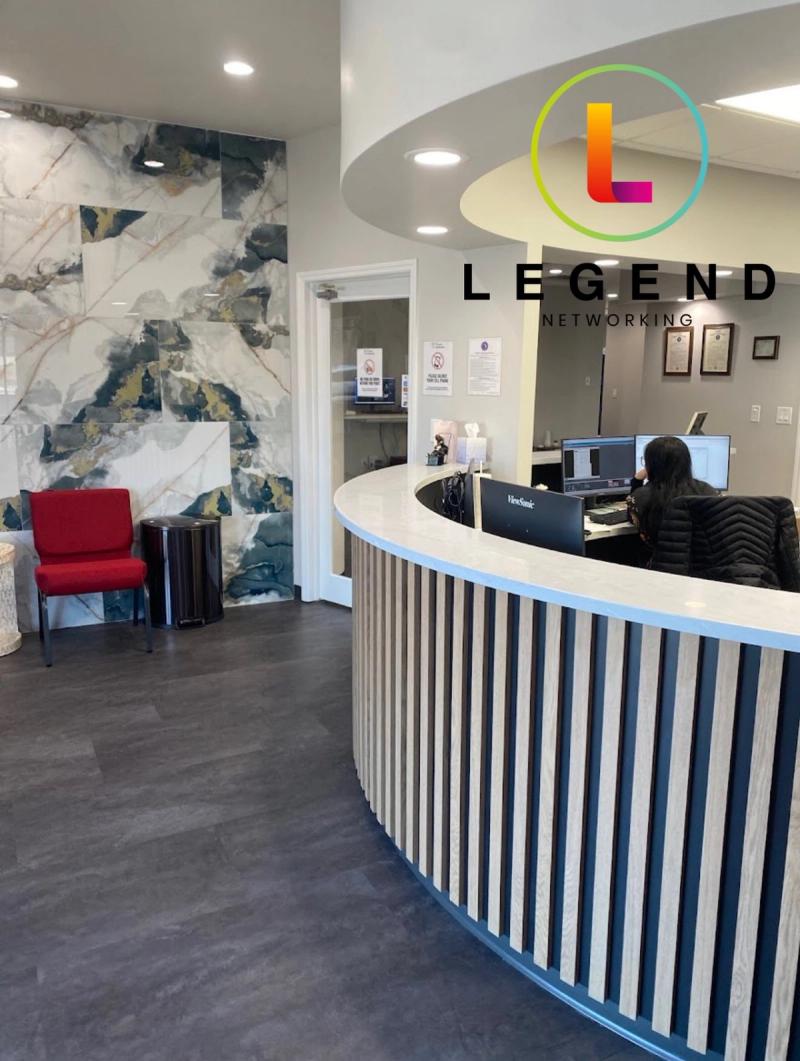 Curved reception counter and waiting area with a marble feature wall at Tampa Endodontics in Tampa