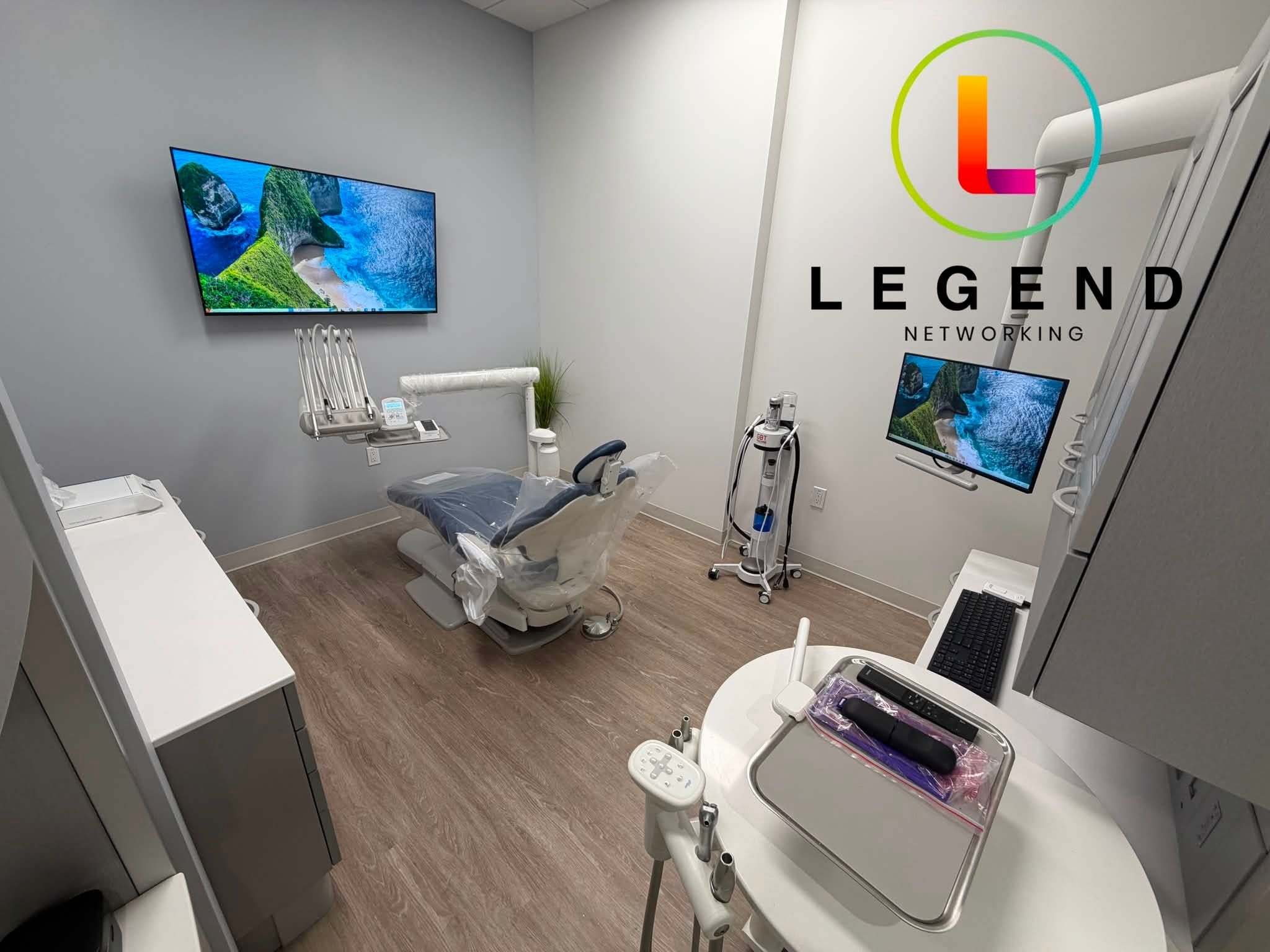 Treatment room at Trueform Dental with a dental chair and a wall-mounted display.