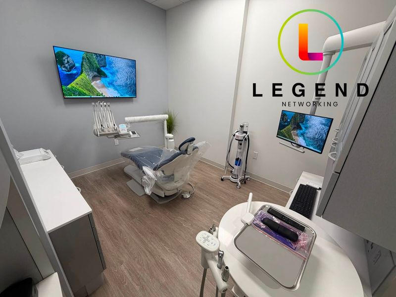 Treatment room at Trueform Dental with a dental chair and a wall-mounted display.