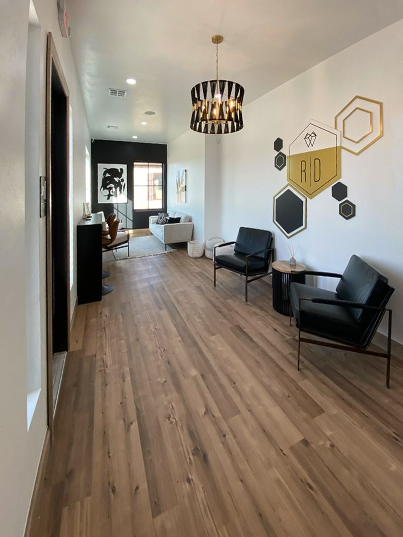 Waiting area with seating and a wall logo at Revive Dental in Edmond