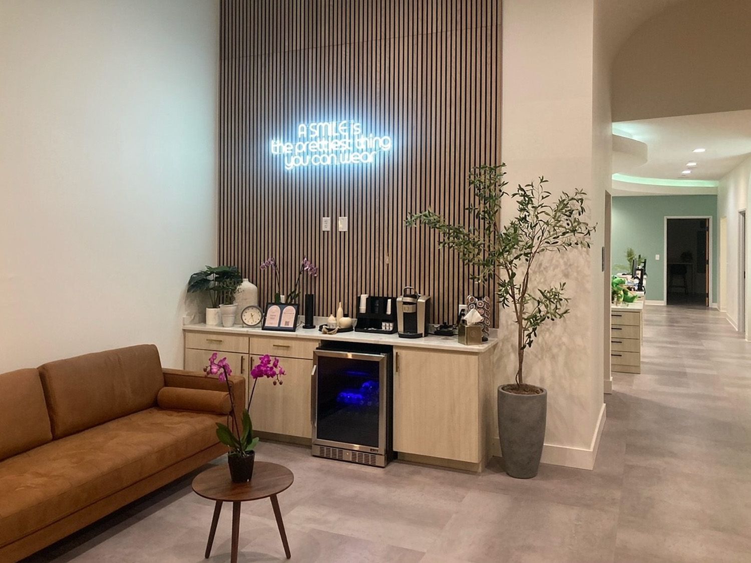 Waiting area with sofa and neon sign at Local Dental in San Antonio