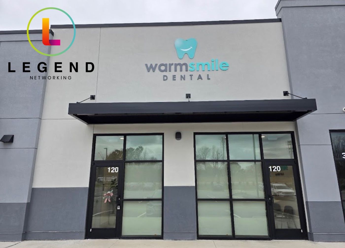 Storefront with the Warm Smile Dental sign above the glass entry doors in Raleigh, NC