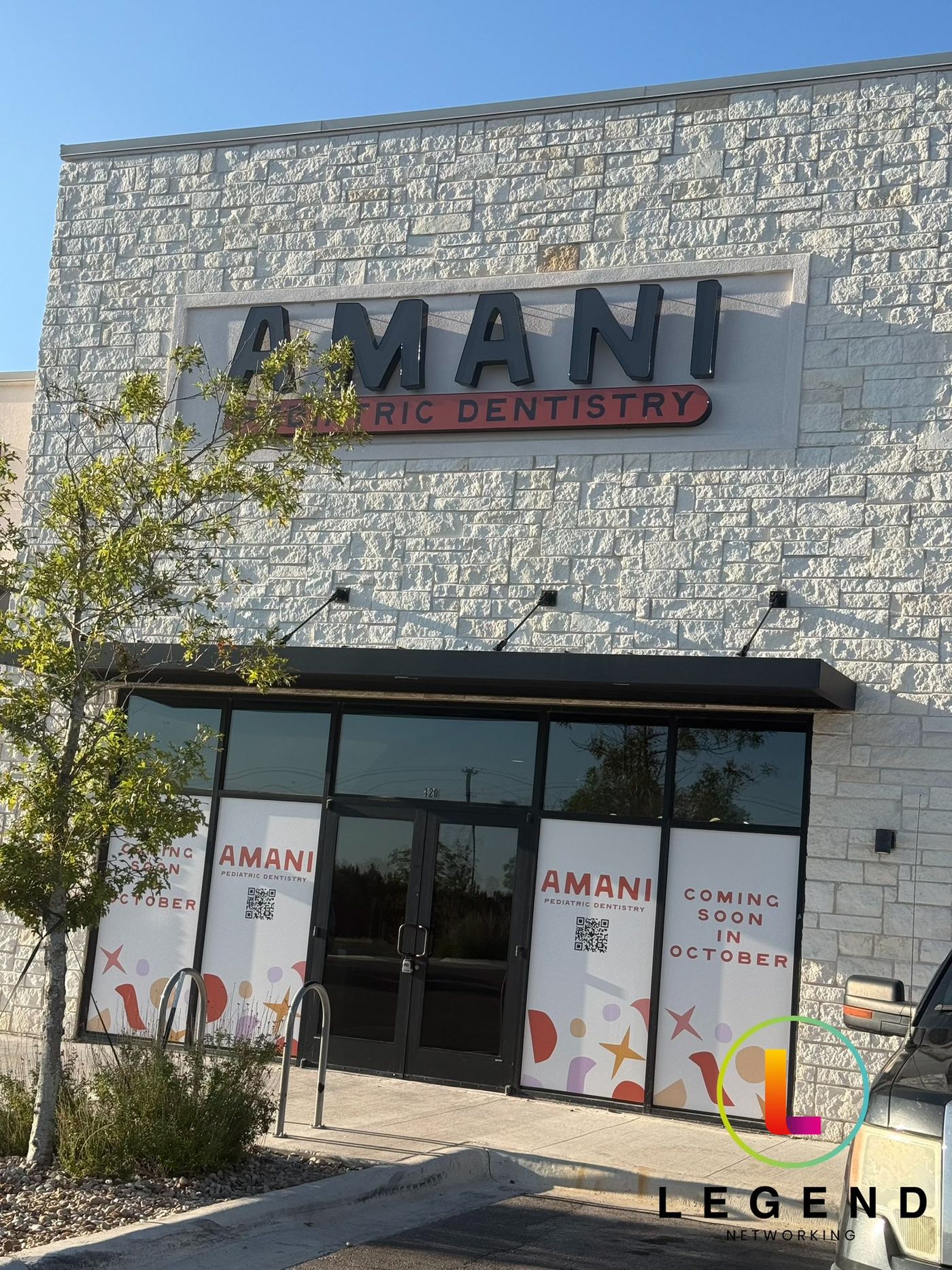 Storefront with Amani Pediatric Dentistry sign and coming soon window graphics in Cedar Park, TX