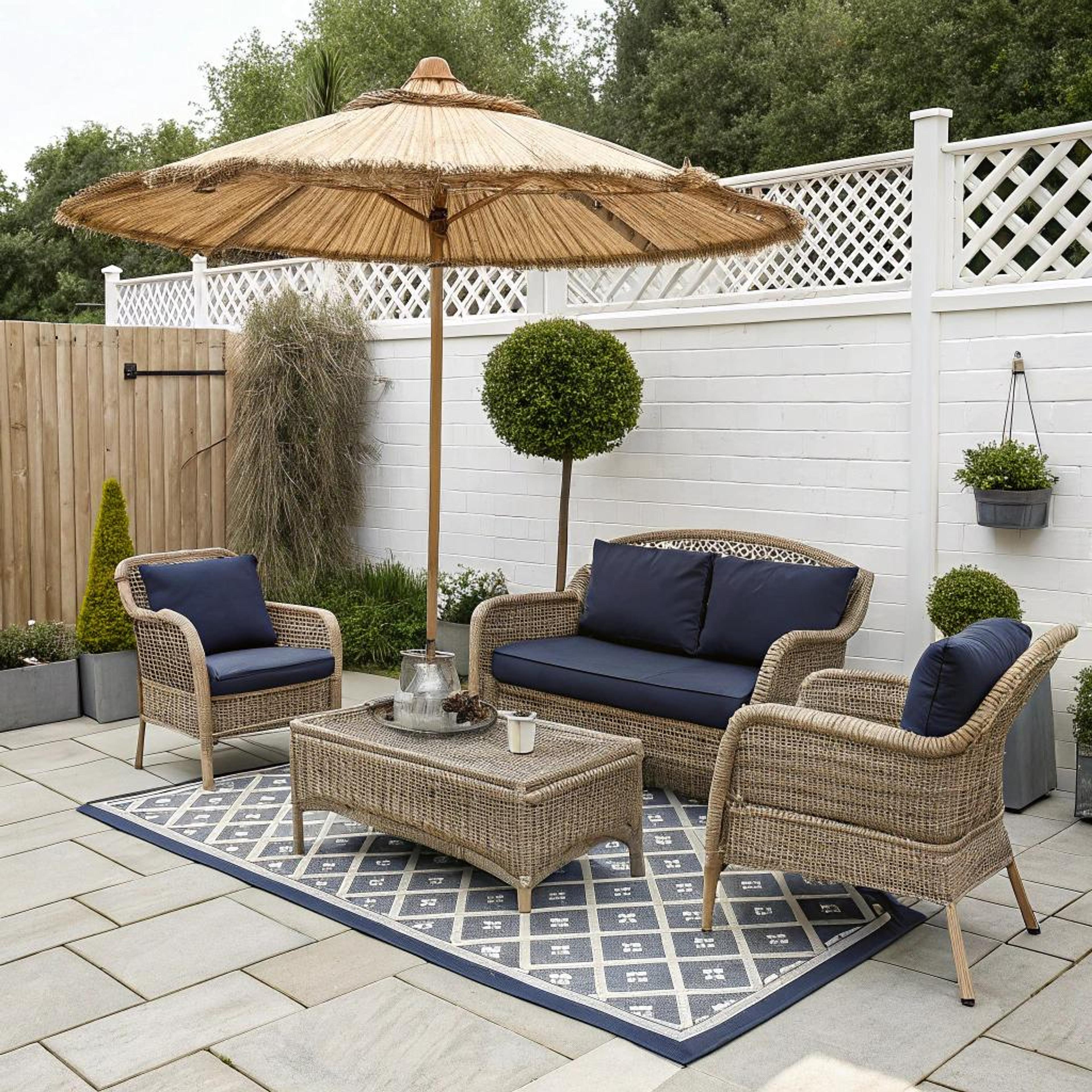 Rotanmeubels onder rieten parasol