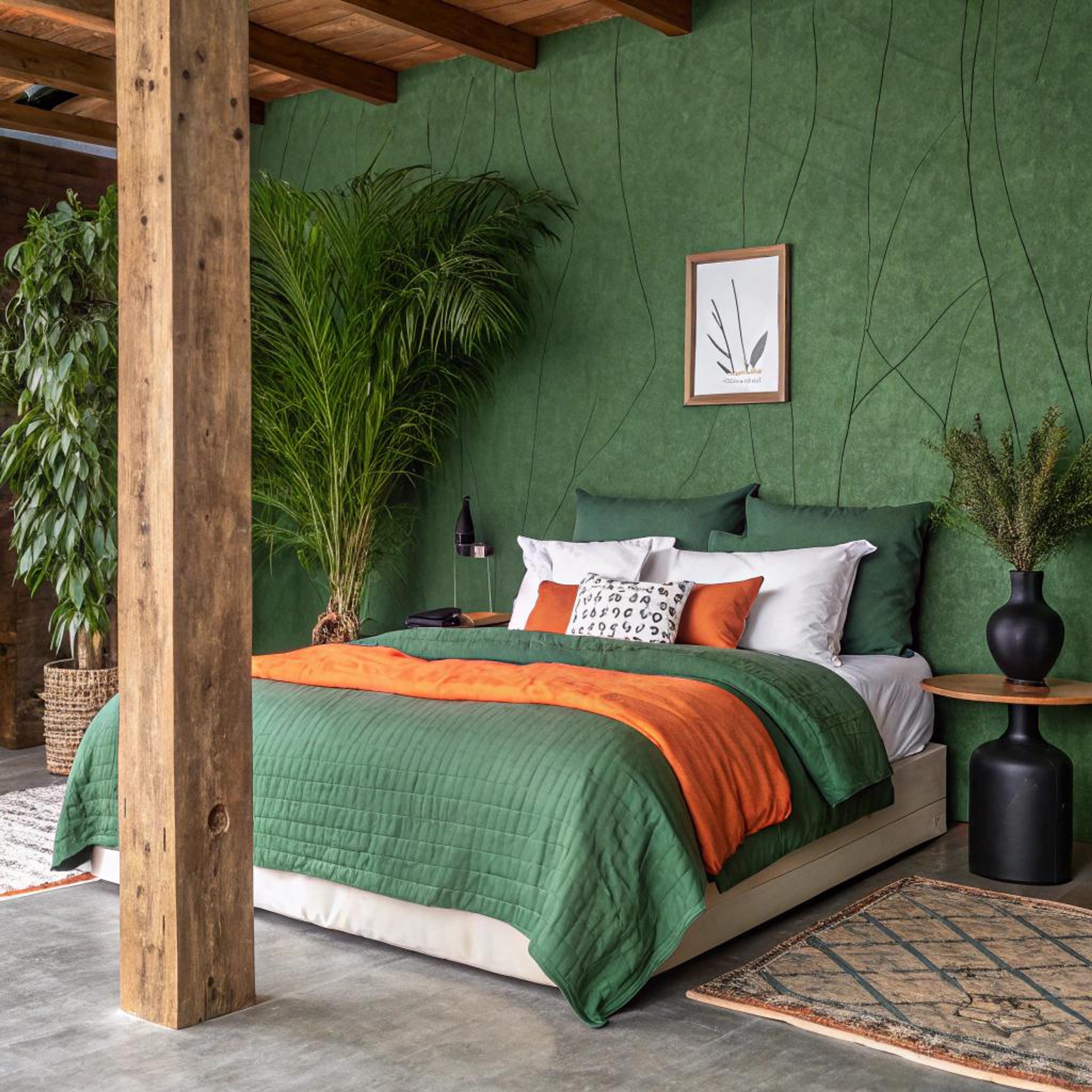 Groene wand en oranje beddengoed