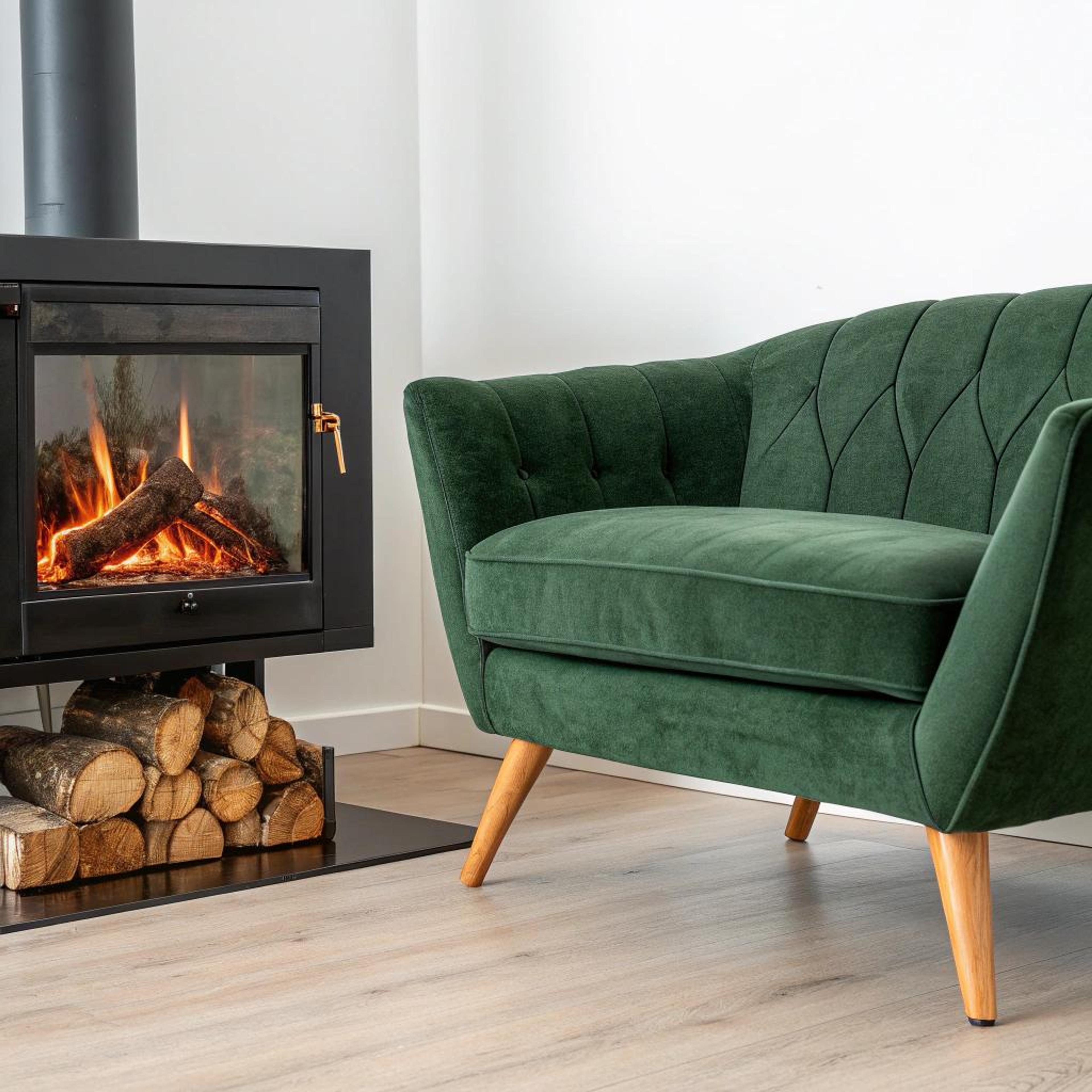 Groene fauteuil naast haard
