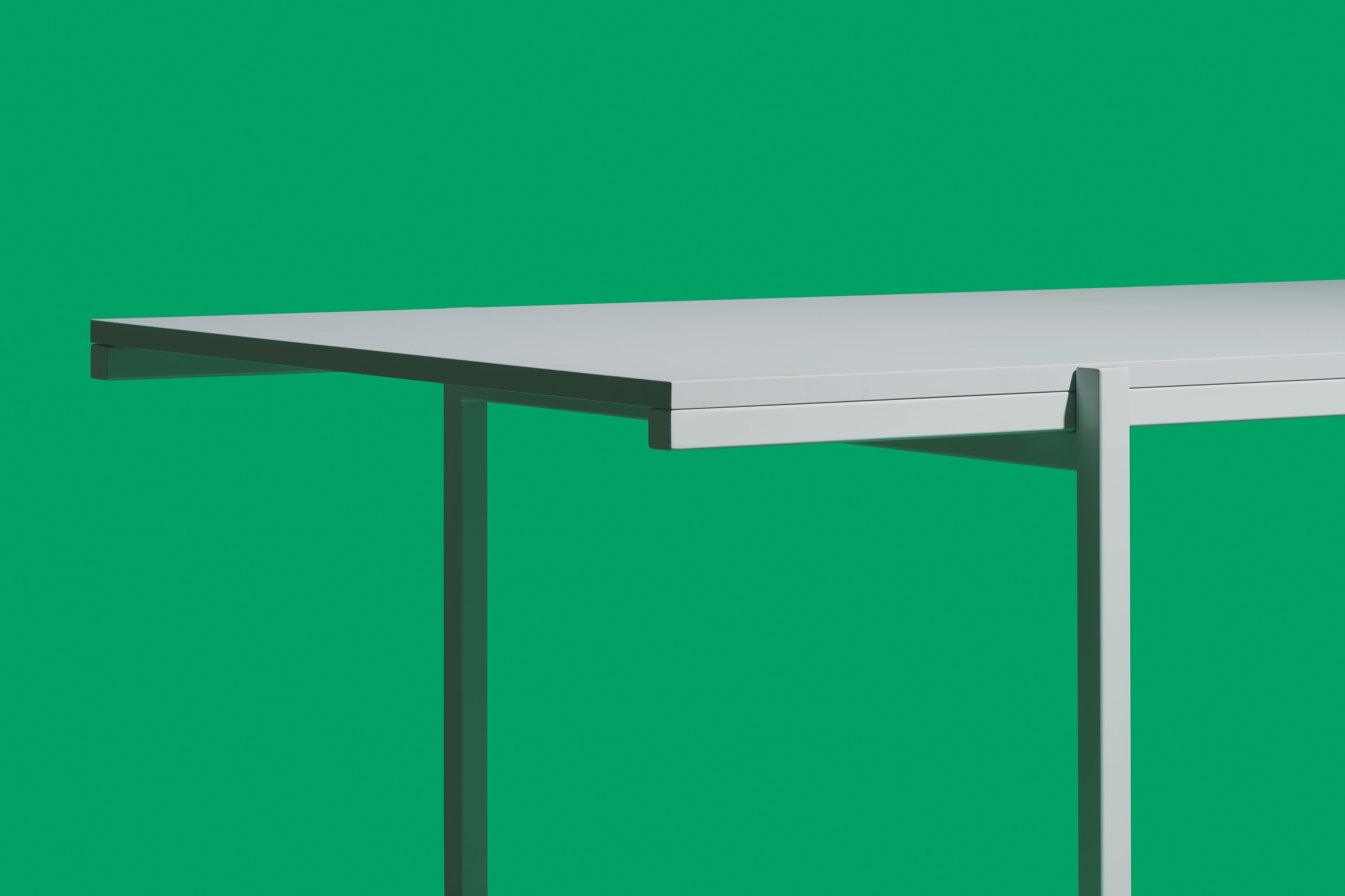grey minimalist design table in front of green background