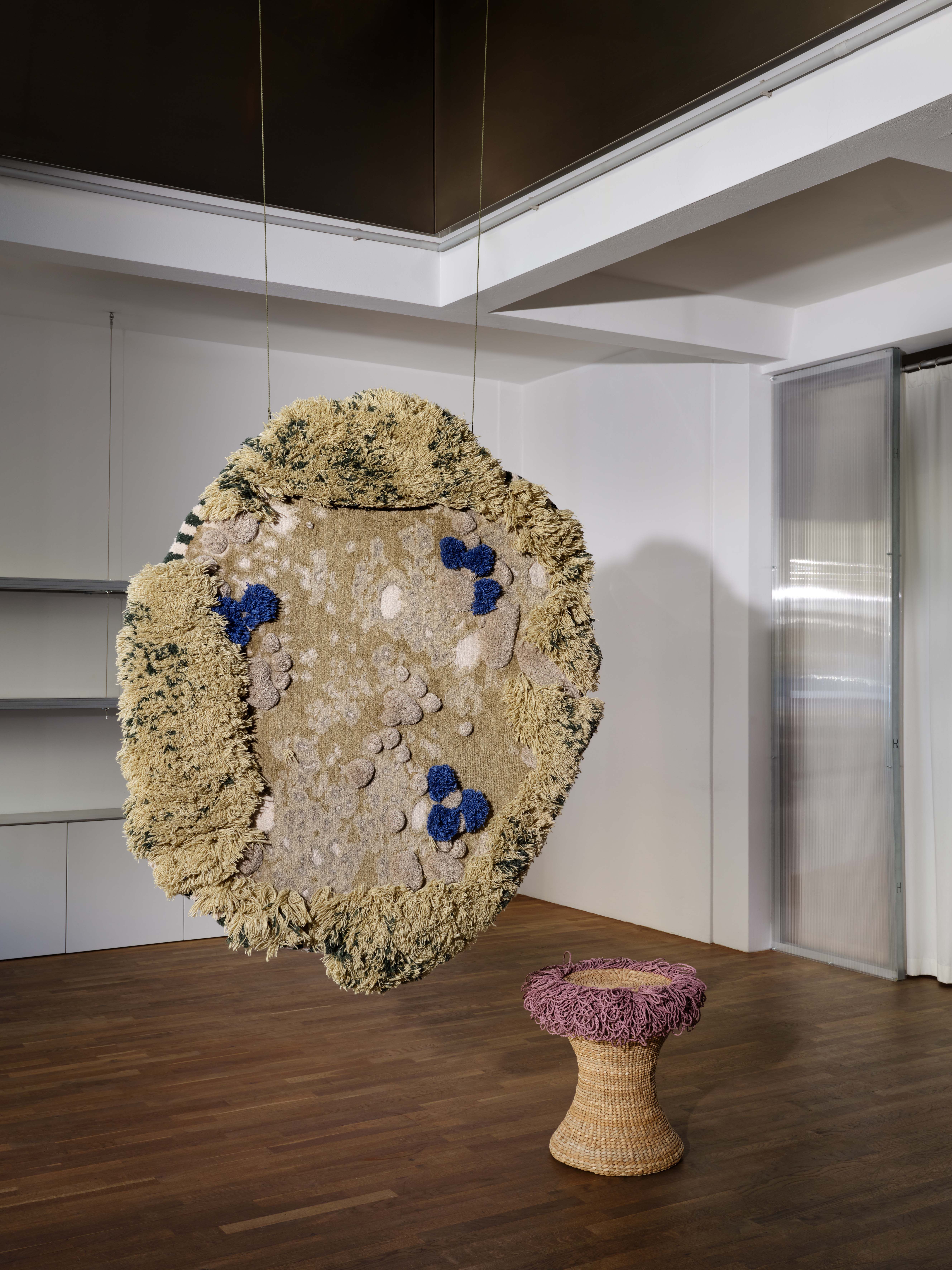 A carpet hanging from the ceiling and a stool