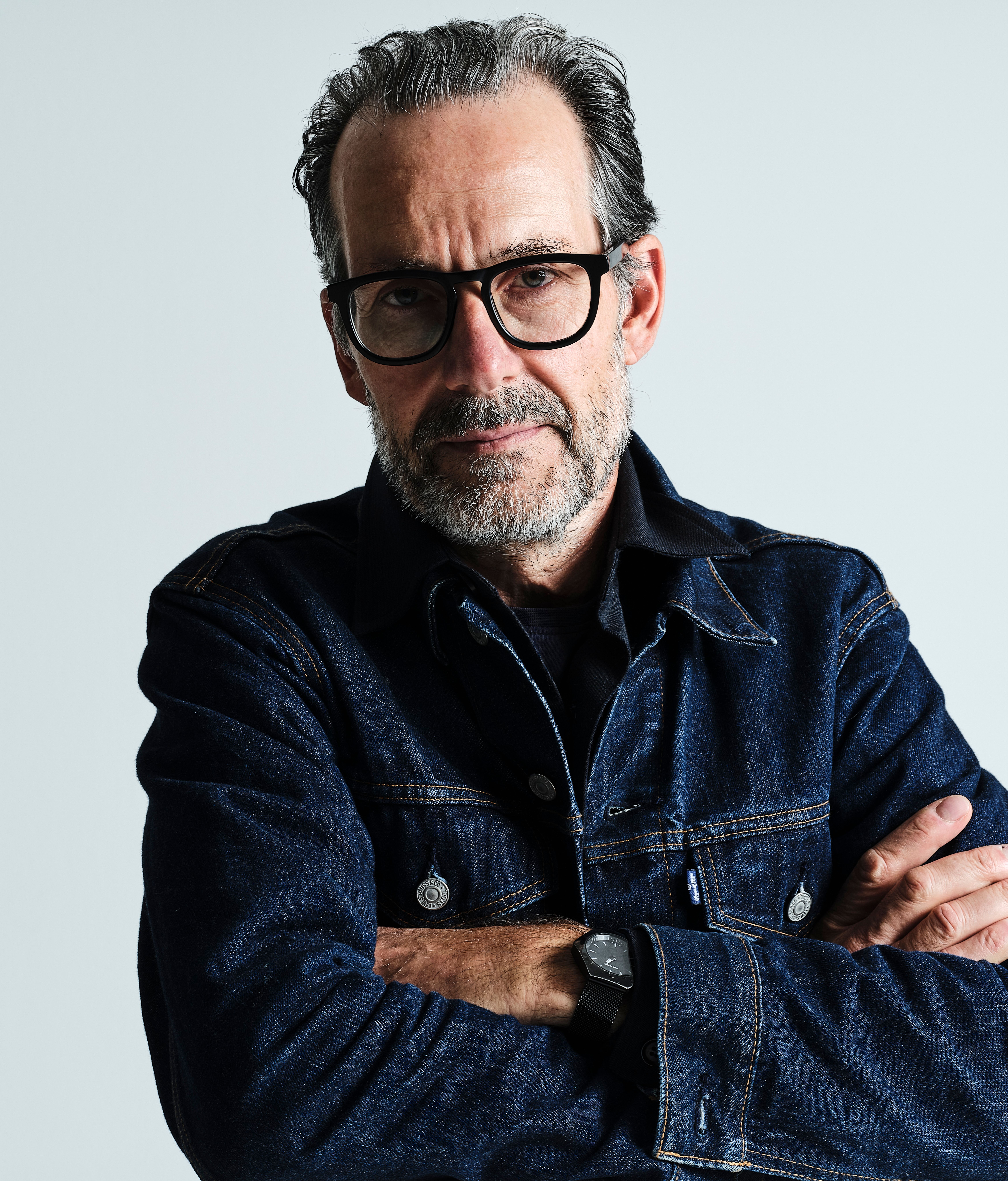 a portrait of a man in a jeans jacket