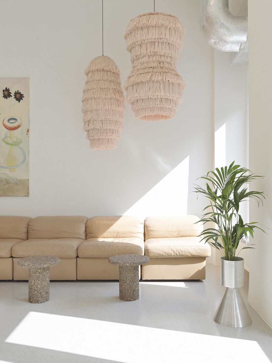 A beige Sofa, two side tables and a planter