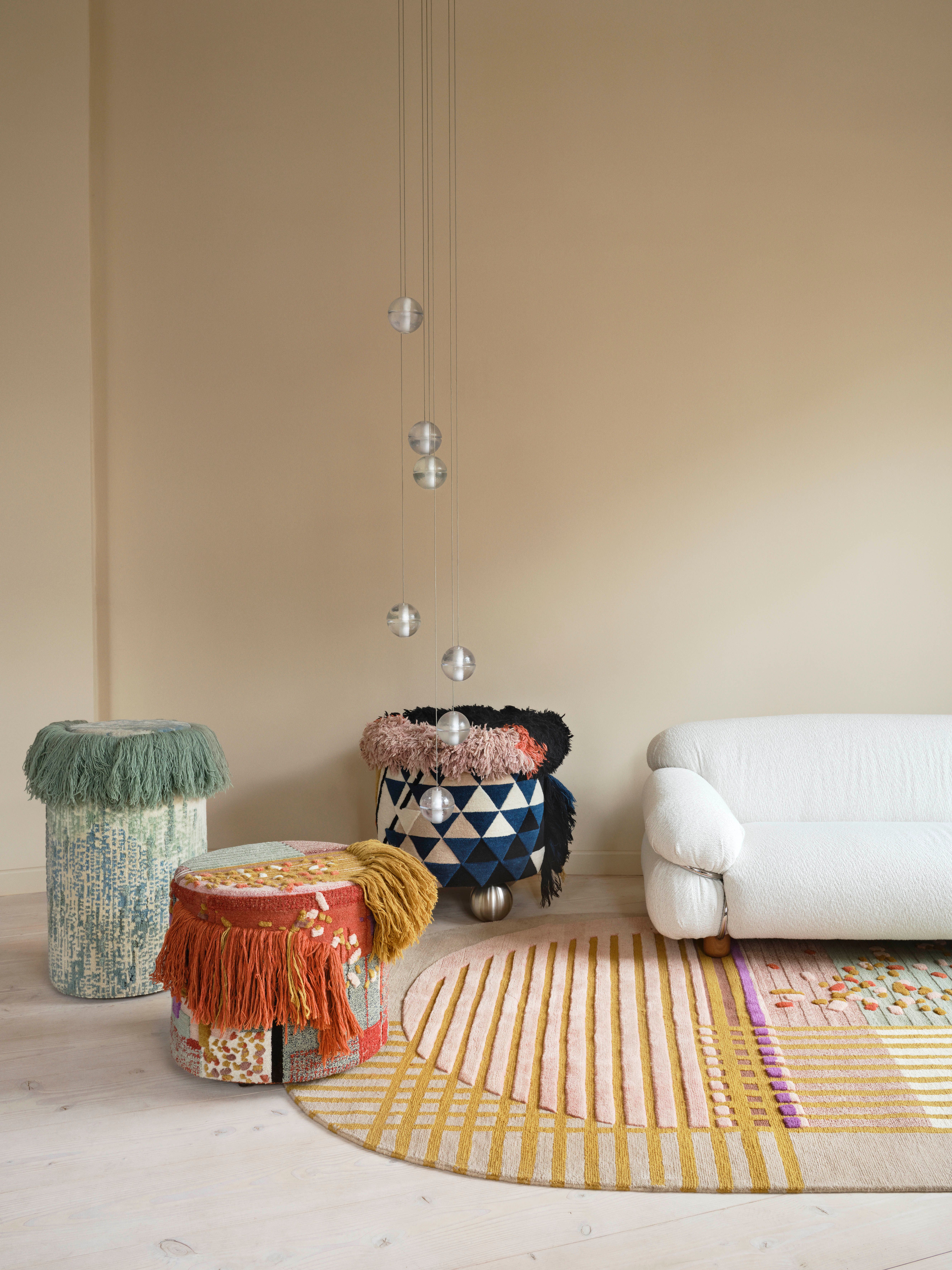 A sofa on a carpet with three different textile objects