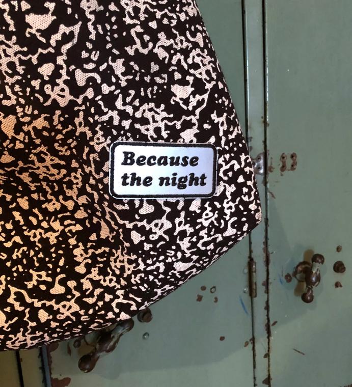glowing "because the night" patch on a bag