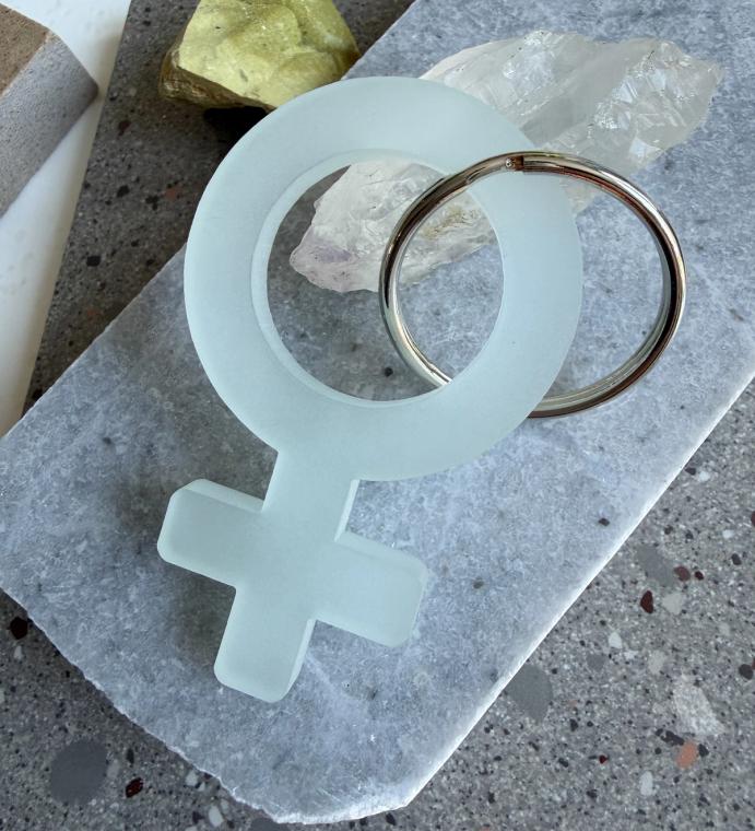 A frosted mint woman symbol keychain