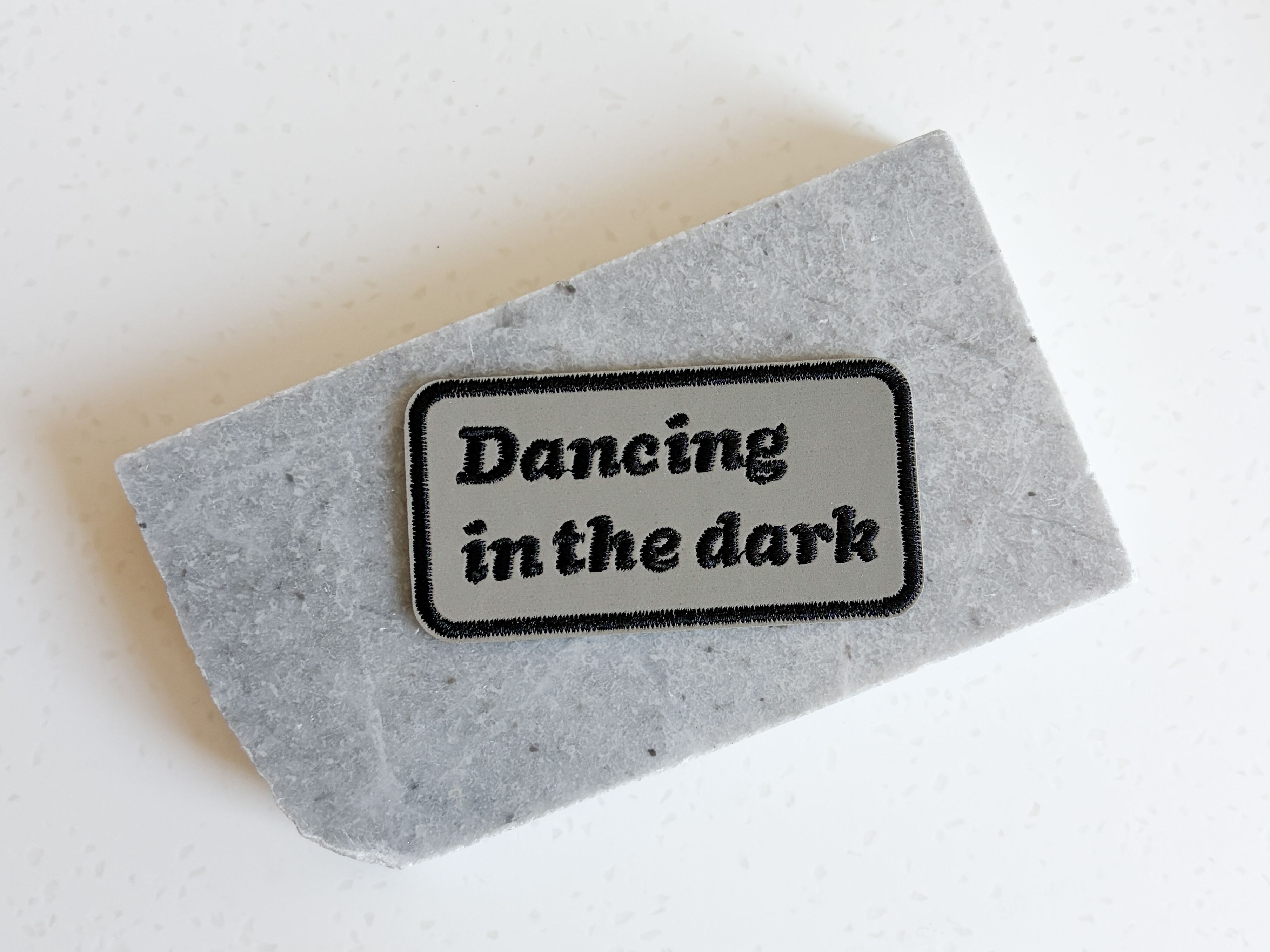 A patch that reads "dancing in the dark"