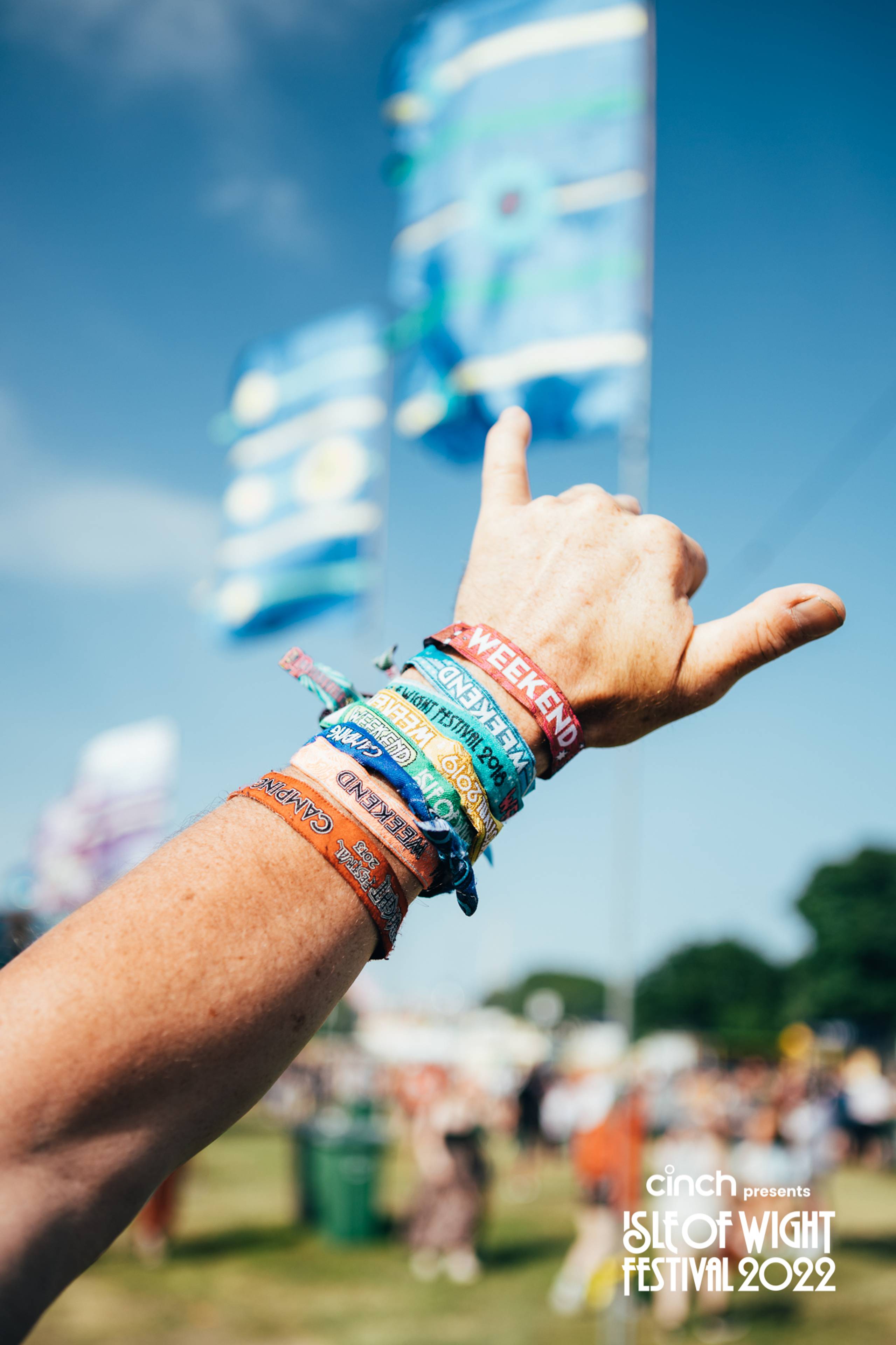 Someone's arm sticking out with 8 festival wristbands