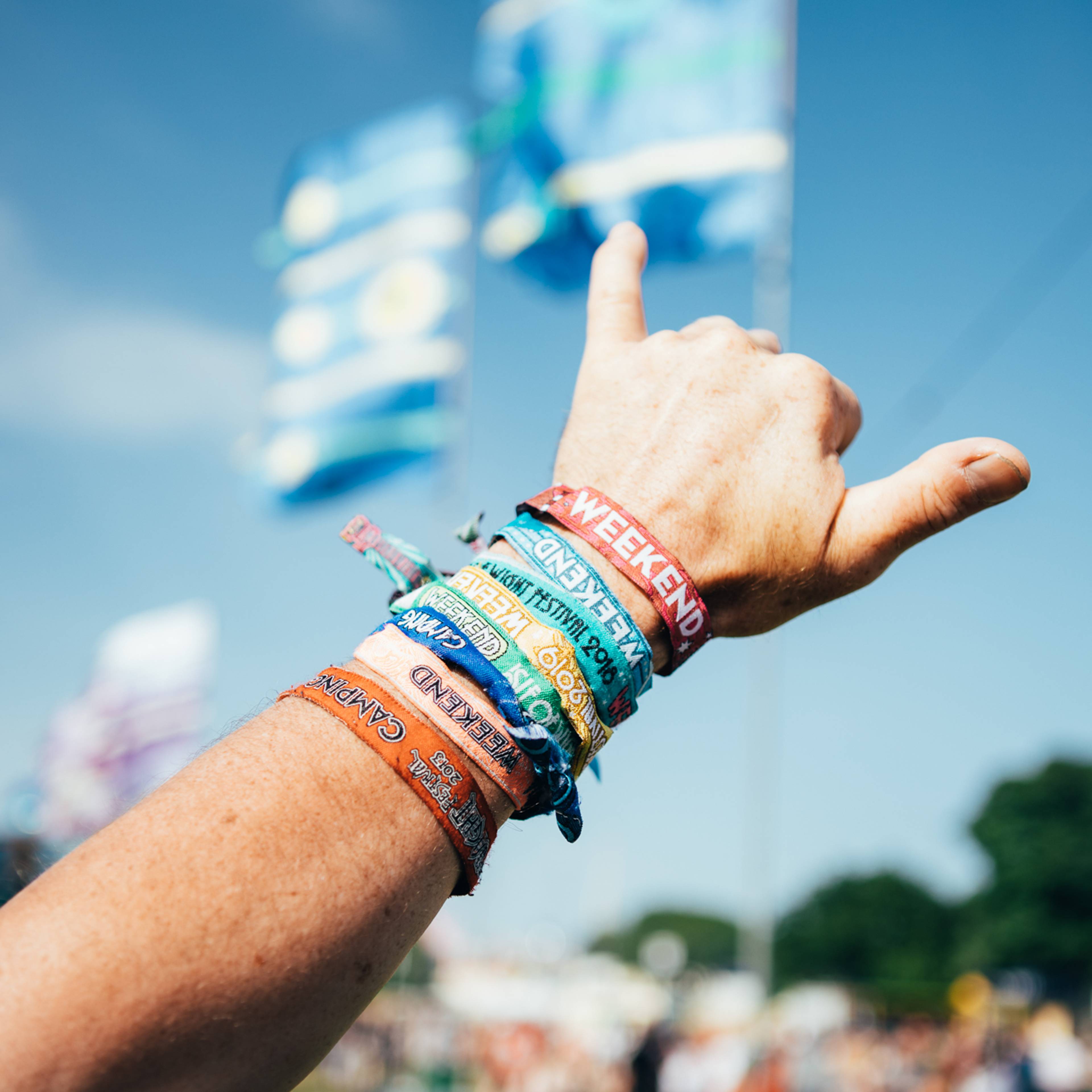 Someone's arm sticking out with 8 festival wristbands