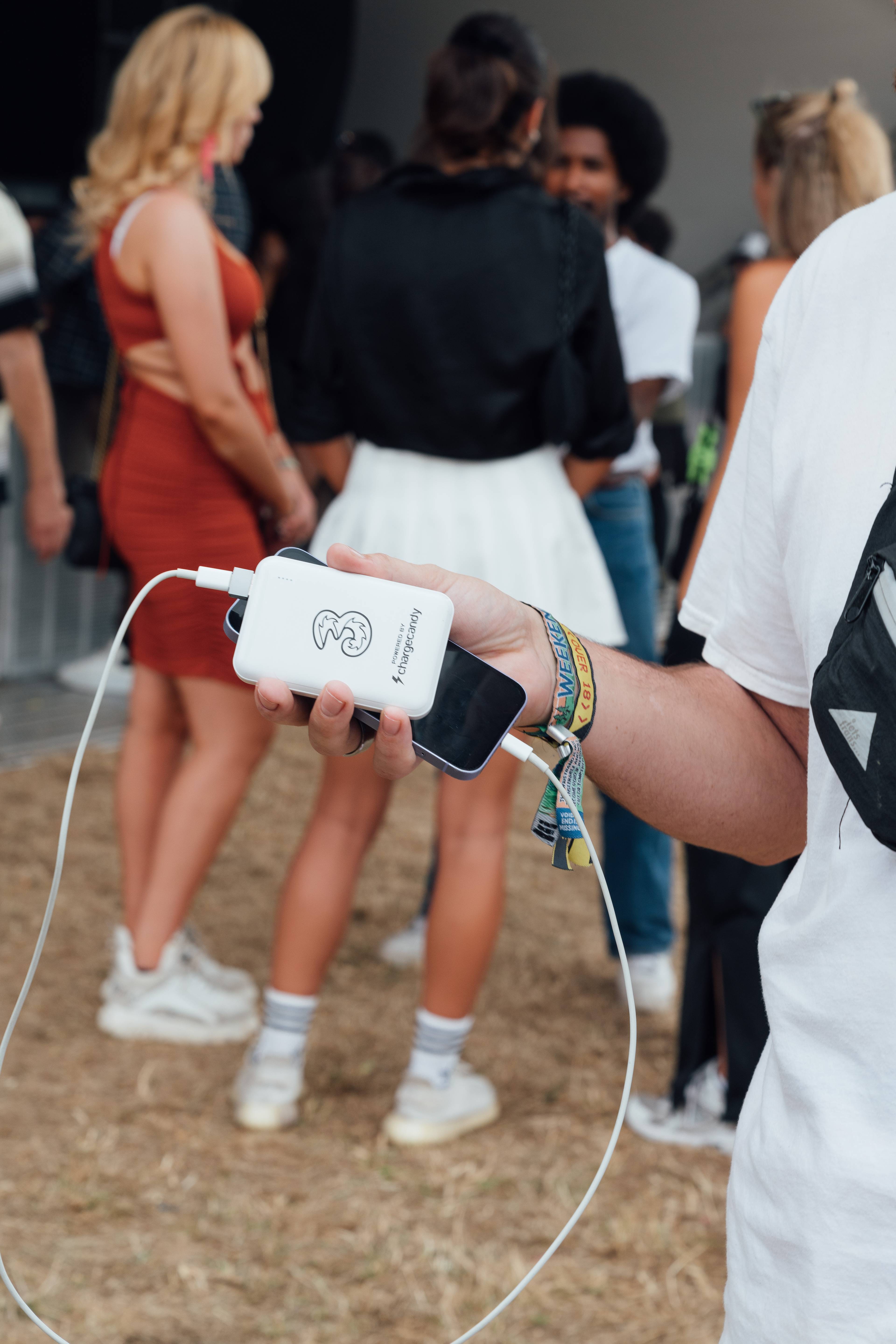 A person holding their phone attached to a portable charger